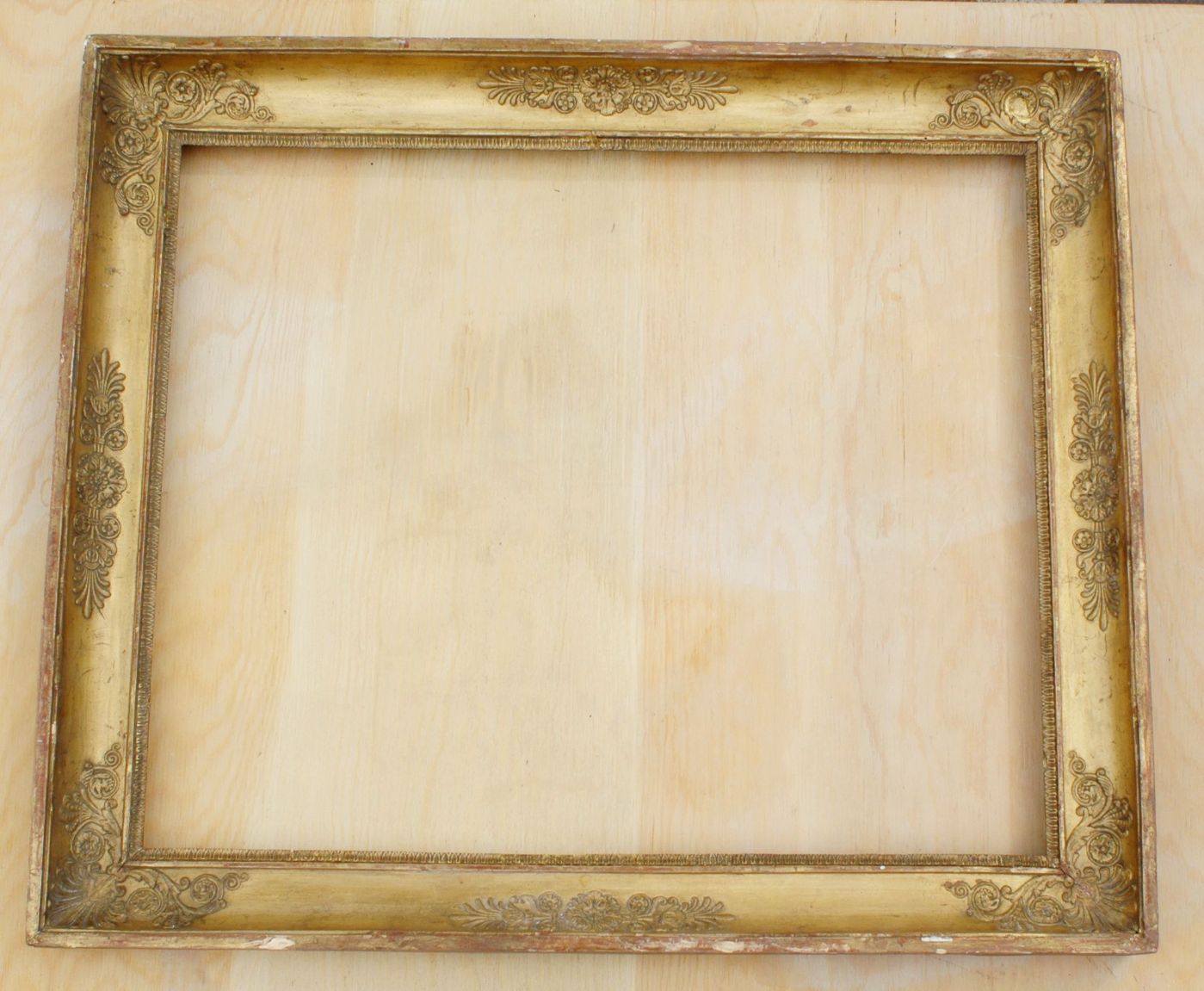 Specchiera in legno dorato Impero a guscia,4 angoli a centri con decori a rilievo Primi XIX ° sec.luce cm.49 x 61 est.54 x64